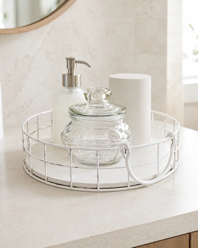 White wire vanity tray styled with glass bottles and apothecary jars